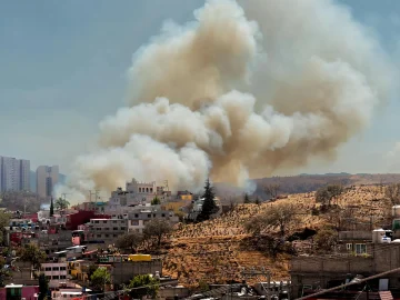 Firefighters battling the Amsterdam scrap yard fire as thick smoke rises over the western harbor area