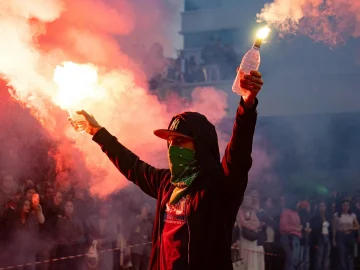 Protesters holding banners and flares during the asylum center protest near the A59 in Den Bosch