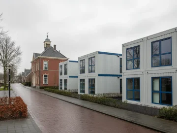 Editorial visual about realistic Dutch public administration exterior: modest municipal-style building and tempor