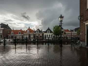 Storm clouds clearing over a wet Dutch street after warm weather