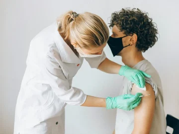 Dutch tourist measles Panama health alert — a traveller at an international airport with a health notice board visible