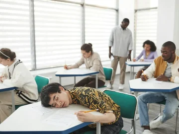 Student sitting at a desk looking stressed during exam season, representing the LAKS stress hotline initiative