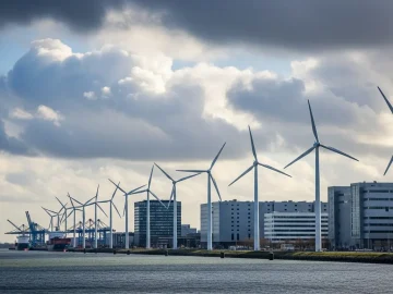 News image about realistic Dutch renewable energy stock photo: wind turbines near an urban-industrial water