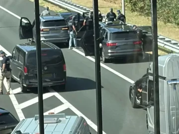 Plainclothes and tactical police officers surround cars stopped on a motorway during the arrests that followed the armed raid in Overasselt, 1 September 2026