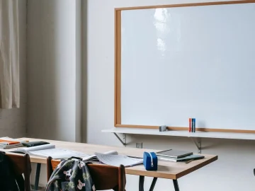 Classroom with desks, books and a whiteboard